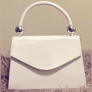 White patent leather vintage style purse with silver detail and cross chain